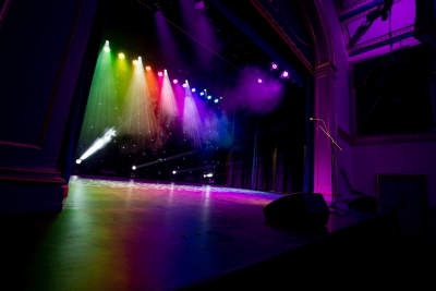 Tamworth Assembly Rooms stage in the dark with multicoloured lights lighting up the stage